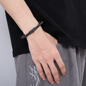 Détail du bracelet en acier noir à texture câble avec fermoir géométrique porté au poignet