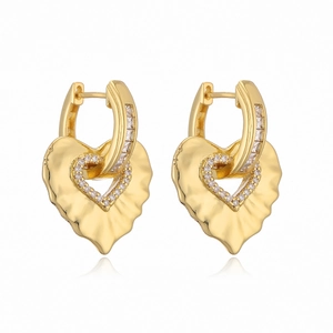 Irregular textured gold heart earrings with zircon inlay against white background