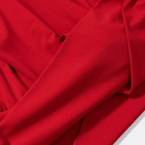 Gros plan sur la texture du tricot plissé rouge vif avec détails d'épaulettes douces
