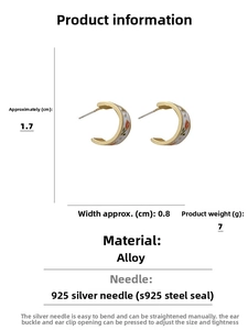 Detail view of gold C-shape earrings with white enamel and red tulip floral pattern