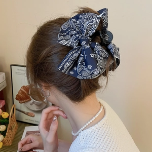 Vue détaillée d'une grande pince à cheveux avec nœud cachemire bleu marine portée