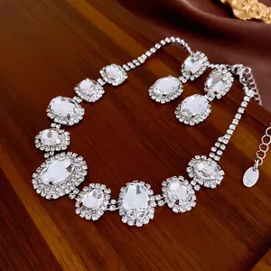Luxurious oval crystal jewelry set with necklace and earrings on premium silk fabric