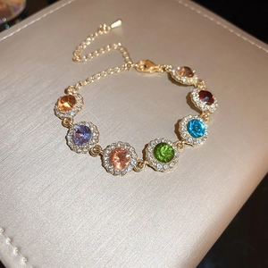 Détail d'un bracelet de pierres précieuses colorées serties d'or sur un coffret à bijoux