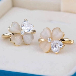 Elegant gold clover earrings with cat eye stone petals and heart-shaped cubic zirconia