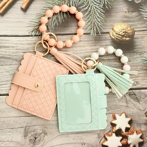Silicone bead keychain bracelet with woven PU leather wallet and tassel on wooden surface