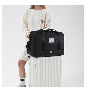 Black quilted travel bag with star pattern fixed on luggage handle via trolley sleeve