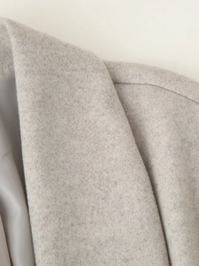 Detailed close-up of light gray wool blend fabric and smooth inner lining on the collar