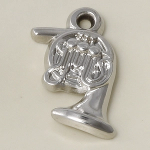 Macro shot of a silver 304 stainless steel French horn pendant with relief details