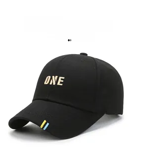 Detail of black cotton baseball cap featuring gold ONE embroidery and colorful side tape