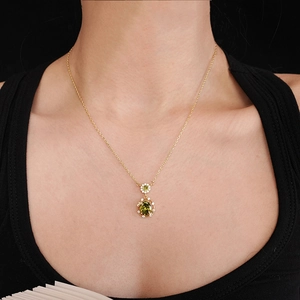 Detailed macro shot of an 18K gold plated vintage necklace with oval green zircon pendant