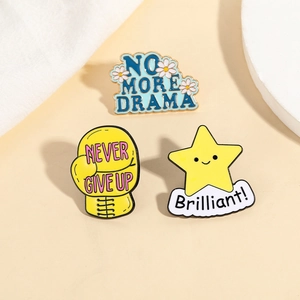 Three enamel pins featuring NO MORE DRAMA flower, NEVER GIVE UP glove and star designs