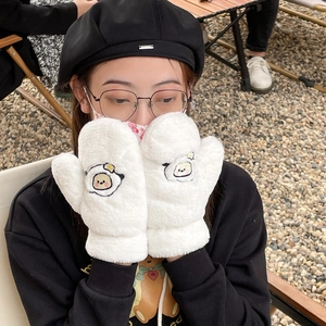 Detailed view of white plush mittens with cute egg character embroidery and ribbed cuffs