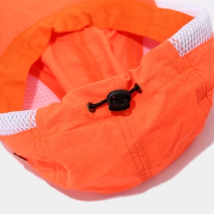 Detail of orange sun hat featuring adjustable toggle, elastic cord, and mesh lining