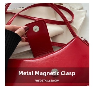Detail of red patent leather shoulder bag with polished silver magnetic hardware snap
