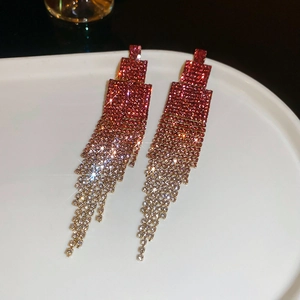 Detailed close-up of sparkling geometric tassel earrings with red gradient rhinestones