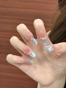 Close-up of blue leopard print press-on nails with cat eye finish and 3D bow details
