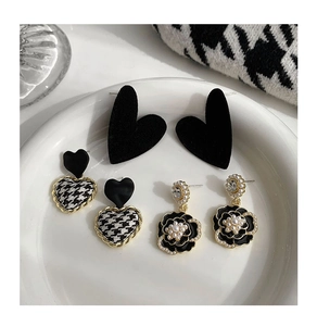 Three pairs of elegant stud earrings featuring black velvet hearts and camellia flowers