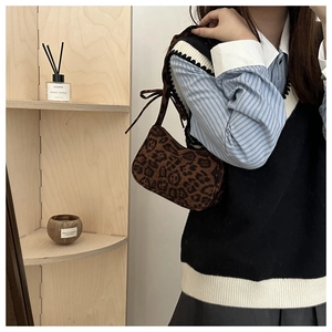 Détail du sac à bandoulière léopard avec sangle nouée porté par un mannequin femme