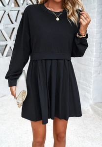 Détail d'une robe décontractée à manches longues avec haut sweat noir et jupe plissée