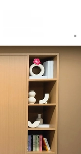 Macro detail of matte white ceramic vases with geometric shapes on wooden shelf
