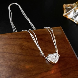 Detail of silver multi-layer snake chain with sparkling heart crystal pendant