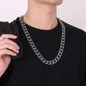Detailed view of silver Cuban link necklace with skull engraving on male model
