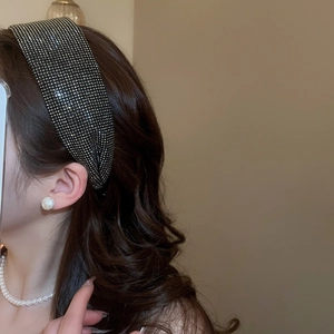 Close-up of wide black headband with sparkling silver rhinestones on female model