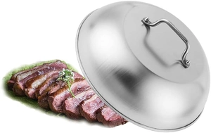 Polished stainless steel food cover with metal handle next to a plate of steak