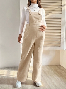 Close-up of beige corduroy maternity overalls showing fabric texture and elastic waist
