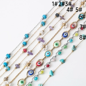 Detail of eight stainless steel jewelry chains with evil eye charms and natural stone beads