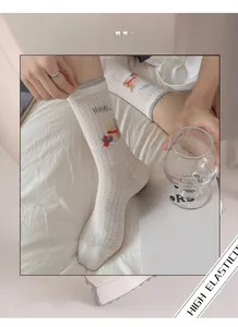 Detail of high elasticity mesh socks featuring cartoon bear pattern and soft ribbed cuff