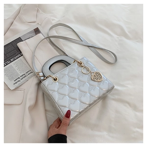 White heart quilted handbag with top handle and decorative heart charm