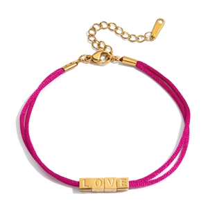 Détail macro des perles LOVE sur bracelet en corde rose avec finition plaquée or 18 carats