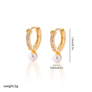 Detail of gold-plated earrings with pearls, zircon stones and measurement labels