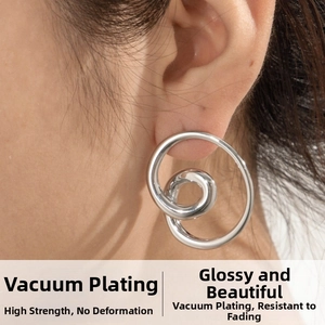 Detail of silver spiral loop earrings with vacuum plating on female model's ear