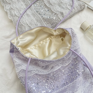 Macro view of purple lace tote bag featuring silver sequins and pearl embellishments