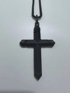 Vue macro détaillée d'un pendentif croix noire en acier inoxydable avec sa chaîne à billes