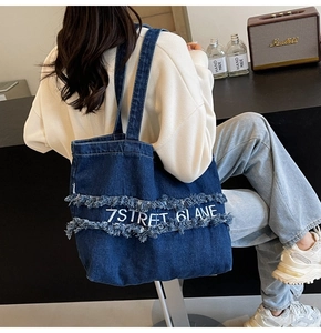 Détail du sac cabas en denim bleu foncé avec broderie 7STREET 6LANE et franges