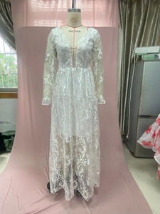 Detail of white lace wedding dress featuring deep V-neck and floral embroidery patterns