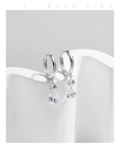 Détail de boucles d'oreilles créoles en argent S925 avec zircons en forme de gouttelette