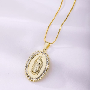 Vue macro d'un collier pendentif Vierge Marie doré avec zircons sur tissu blanc doux