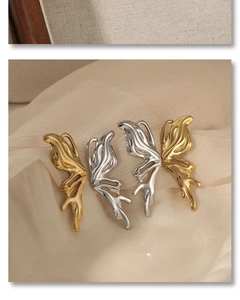 Detailed close-up of butterfly wing earrings in liquid gold and silver metallic finishes