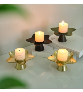 Macro detail of Nordic star-shaped metal candle holders with warm burning aroma candles