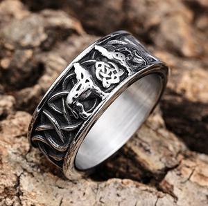 Macro detail of vintage Viking wolf ring with Celtic knot relief on tree bark
