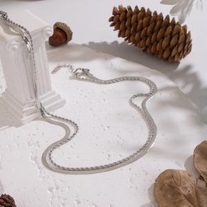 Dettaglio della collana a doppio strato d'argento con catena serpente su marmo