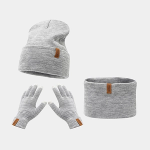 Detail of the knit texture and leather brand labels on the gray winter hat scarf glove set
