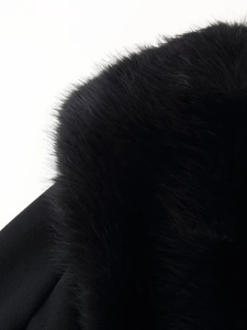 Détail du col en fourrure noire sur un manteau en laine montrant la texture riche
