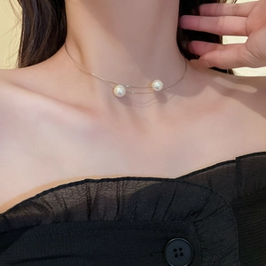 Gros plan d'un choker argenté minimaliste avec deux perles sur le cou d'une femme