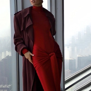 Détail d'une robe moulante rouge à col montant avec un nœud élégant à la taille