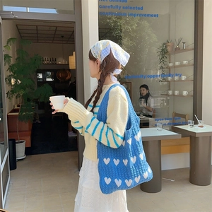 Detailed knit texture of blue heart pattern tote bag with soft crochet wool material